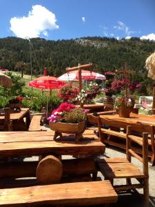 a group of wooden picnic tables with flowers on them at La Godille in Andon