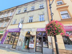 a building on a street with flowers in front of it at Apartament Baza in Przemyśl