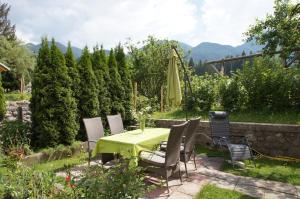 un patio con mesa, sillas y sombrilla en Apartments Mencinger, en Bohinj