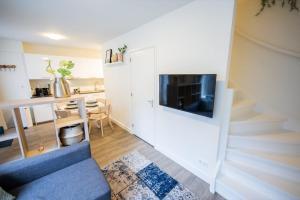 a living room with a staircase and a blue couch at Delightful 2 Bedroom Apartment in Eindhoven