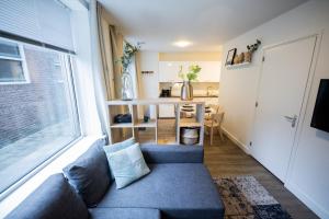 a living room with a couch and a large window at Delightful 2 Bedroom Apartment in Eindhoven