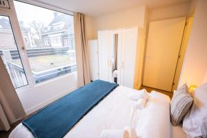 een slaapkamer met een bed en een groot raam bij Delightful 2 Bedroom Apartment in Eindhoven