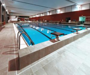 - une grande piscine dans un grand bâtiment dans l'établissement La Villa Marne - 15mn Paris Gare du Nord, Parking Privé Gratuit, Tout équipée, Terrasse, Jardin, Stade de France, Casino d'Enghien, Hippodrome, Université, à Épinay-sur-Seine