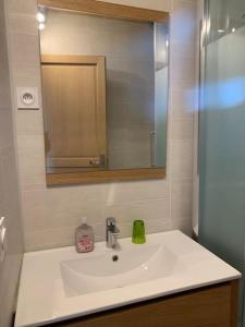 uma casa de banho com um lavatório branco e um espelho. em Appart style chalet superbe vue, SKI VIP remise 20 % em Font Romeu Odeillo Via