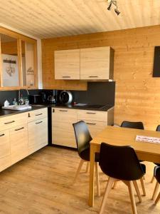 uma cozinha com uma mesa e uma mesa e cadeiras em Appart style chalet superbe vue, SKI VIP remise 20 % em Font Romeu Odeillo Via