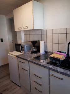 a kitchen with white cabinets and a counter top at Ferienwohnung Rasch in Schierke