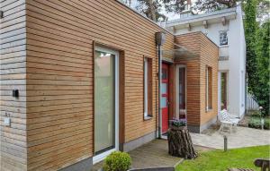 ein Haus mit Holzverkleidung und einer Terrasse in der Unterkunft Beautiful Home In Seebad Lubmin With Wifi And 3 Bedrooms in Lubmin