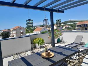 patio con mesa y sillas en el balcón en Penthouse Aurelia, rooftop terrace & jacuzzi, en Turanj