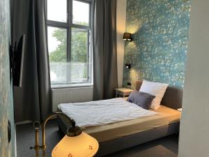 Un pat sau paturi într-o cameră la Hoffmanns Holsteinisches Haus