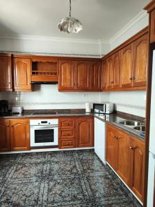 una cocina con armarios de madera y electrodomésticos blancos en Bernal I, II y III en Los Sauces