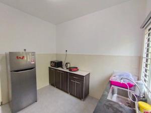 eine Küche mit einem Kühlschrank aus Edelstahl und einer Spüle in der Unterkunft No 70 Sunlight Homestay 4R3B - 24 Pax, Karaoke in Kuala Selangor