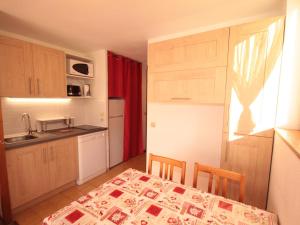 a kitchen with a table and a kitchen with a table and chairs at Appartement Les Saisies, 2 pièces, 5 personnes - FR-1-293-196 in Les Saisies