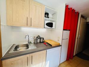 a small kitchen with a sink and a refrigerator at Appartement Les Saisies, 2 pièces, 5 personnes - FR-1-293-196 in Les Saisies