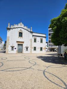 a large white building with a tree in front of it at The Singular - Downtown Studio in Faro
