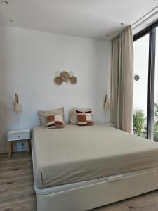 a white bedroom with a large bed and a window at The Singular - Downtown Studio in Faro