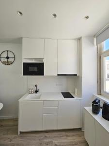 a kitchen with white cabinets and a sink at The Singular - Downtown Studio in Faro