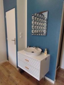 baño con lavabo blanco y pared azul en La Ferme, en Chambles