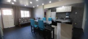- une cuisine avec un comptoir et des chaises bleues dans l'établissement Alojamiento La Familia, à Puerto Iguazú