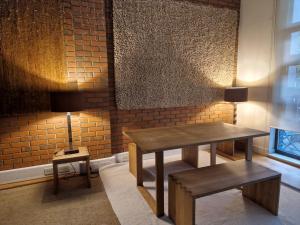a table and bench in a room with a brick wall at Lovely London on a budget! in London