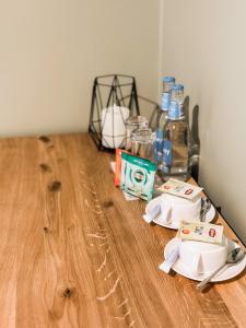 - une table avec 2 assiettes et des bouteilles d'eau sur du parquet dans l'établissement Viesnīca Kandava, à Kandava