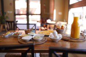 een houten tafel met eieren en een fles sinaasappelsap bij IBEX unique Desert Inn in Mitzpe Ramon