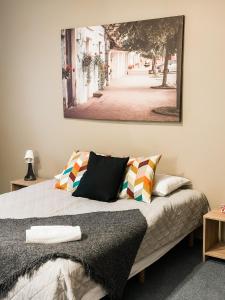 Viesnīca Kandava في كاندافَ: غرفة نوم بسرير مع صورة على الحائط