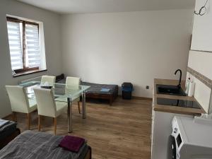 a room with a table and chairs and a kitchen at Apartmán nad Bazilikou 1 in Třebíč