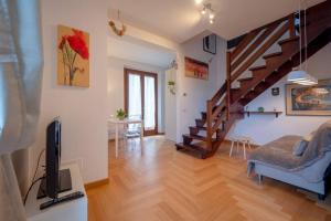 a living room with a television and a staircase at [Apartment near Perugia] - Free Parking & A/C in Badiola