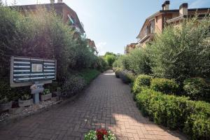a brick path with a sign and some bushes and buildings at [Apartment near Perugia] - Free Parking & A/C in Badiola