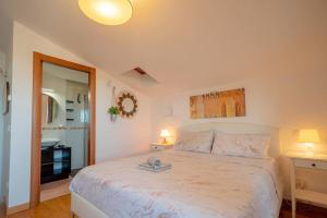 a bedroom with a large white bed and a bathroom at [Apartment near Perugia] - Free Parking & A/C in Badiola