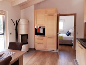 uma cozinha com armários de madeira e uma cama num quarto em Chalet Sisi em Saalfelden am Steinernen Meer