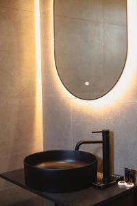 een badkamer met een zwarte wastafel en een spiegel bij Posh Villas in Rrogozhinë
