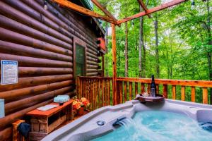 uma banheira de hidromassagem no deque de uma cabina em CABIN in a GATED RESORT with SEASONAL RESORT POOL em Pigeon Forge