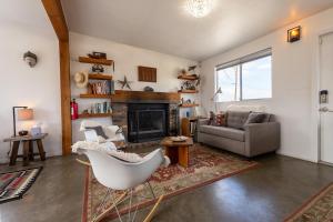 a living room with a chair and a fireplace at The Raven House - Renovated Homestead Cabin in Joshua Tree