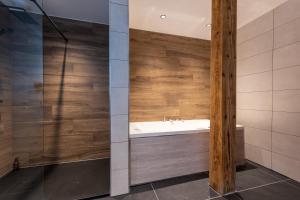 een badkamer met een wastafel en een douche bij Géraniums Et Neige Fraîche, Maison d'Hôtes avec Suites Haut de Gamme, Balnéo massante et Sauna privés in Métabief