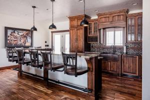 a kitchen with wooden cabinets and a bar with chairs at Hemsley Ranch Guesthouse in Preston