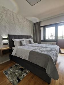 a bedroom with a large bed and a large window at Goreta032 Luxury Apartment 2 in Vukovar