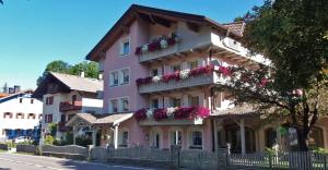 a pink building with flowers on the balconies at Residence Alpenrose in Sesto