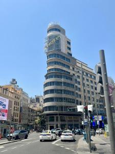馬德里的住宿－米蘭旅舍，一座大型建筑,前面有汽车停放