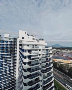 een hoog wit gebouw met uitzicht op een stad bij Azure North Residences by ACC in Lagundi