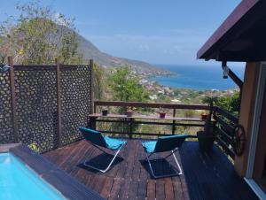 2 sillas en una terraza con vistas al océano en La Villa de Petite Anse - Piscine en Les Anses-dʼArlets