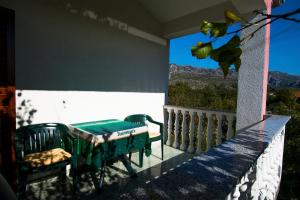 a room with a table and a chair on a balcony at Apartments Žile in Starigrad