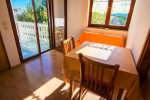 a dining room with a table and chairs and a balcony at Apartments Žile in Starigrad