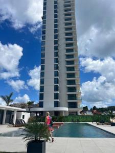 a woman walking in front of a tall building at Luxury Oceanview 1BR on beach in Cupecoy