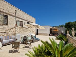een terras met een tafel, stoelen en een parasol bij Villa Teresa in Giovinazzo