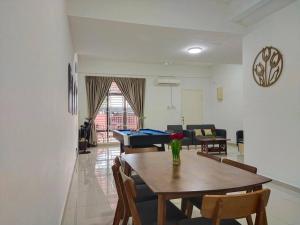 a dining room and living room with a table at No 68 Sunlight Homestay 4R3B - 24 Pax, Karaoke in Kuala Selangor