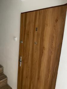 una puerta de madera en la esquina de una habitación en Apartmán nad Bazilikou 2, en Třebíč