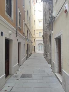 un callejón vacío entre dos edificios en La casa di Uccia, en Trieste