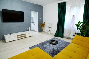 sala de estar con sofá amarillo y TV en RDT Guest House-Rai din Transilvania en Moieciu de Jos
