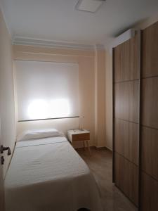a small bedroom with a bed and a window at Delicia, Sol y mar in Málaga